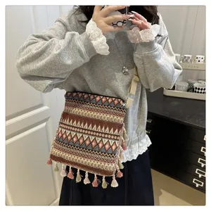 Sac bandoulière tissé de style ethnique pour femme avec motifs géométriques et glands.