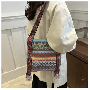 Détail de sac bandoulière tissé de style ethnique, motif géométrique avec franges.