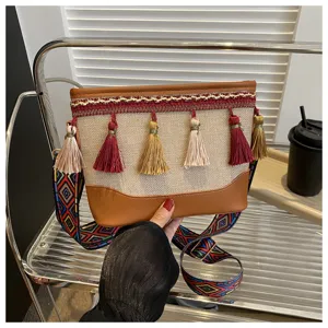 Sac bandoulière en toile style ethnique avec pampilles colorées et large bandoulière.