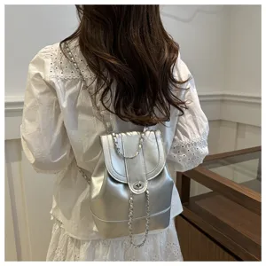 Mini sac à dos métallique argenté avec lanières en chaîne et fermoir, vue de dos détaillée.