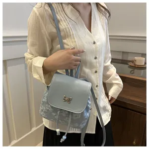 Vue detaillee du mini sac a dos bleu clair elegant avec papillon et details en dentelle florale.