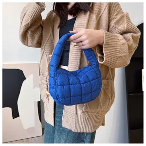 Vue rapprochée du sac à main matelassé bleu stylé montrant sa texture douce et son format compact.