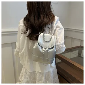 Vue détaillée d'un mini sac à dos argenté tendance avec bretelles chaînes et serrure.