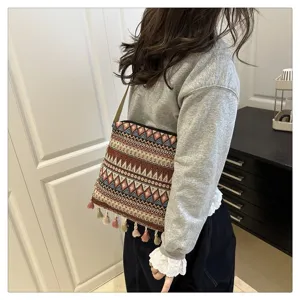 Vue détaillée du sac à bandoulière tissé de style ethnique avec des glands et motifs géométriques.