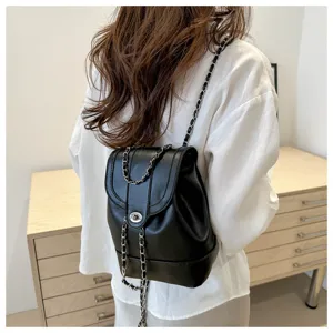 Vue détaillée d'un sac à dos en cuir noir avec bandoulières chaînes et fermoir.