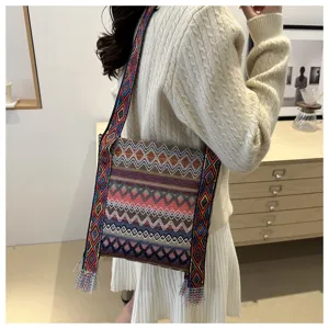 Détail de sac à bandoulière tissé de style ethnique, motif géométrique coloré, large sangle.