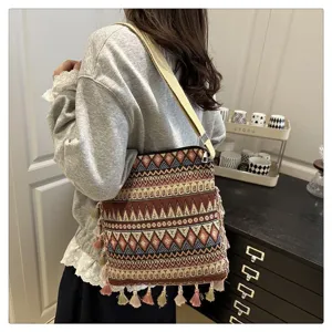 Vue détaillée du sac porté épaule en toile de style ethnique avec franges et large sangle.
