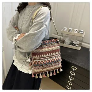 Vue détaillée du sac bandoulière tissé style ethnique avec motifs géométriques et franges.