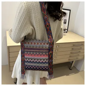Sac à bandoulière tissé style ethnique pour femme avec large sangle géométrique rétro.