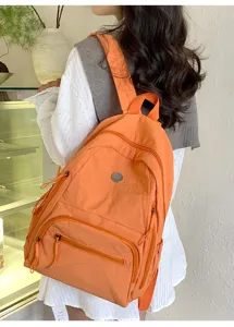 Vue détaillée du sac à dos orange décontracté doté de plusieurs compartiments et bretelles.