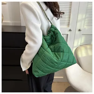 Grüne gesteppte Umhängetasche mit Kette, stilvolles modisches Accessoire im Detail.