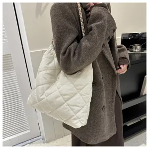 Detailansicht der stylischen weißen gesteppten Schultertasche mit eleganter Metallkette.