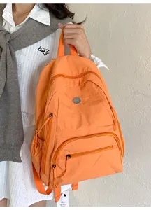 Vue detaillee du sac a dos orange en nylon avec poches zippees pratiques et design.
