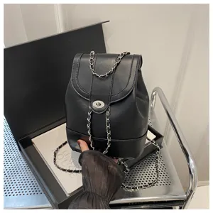 Vue détaillée du sac à dos noir tendance en cuir avec bandoulières chaînes et fermoir.