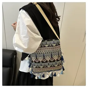 Vue détaillée du sac porté épaule tissé bohème avec motifs ethniques et glands bleus.