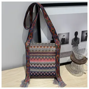 Sac à bandoulière tissé style ethnique avec large sangle et franges. Joli sac pour femme.