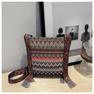 Sac bandoulière tissé style ethnique coloré avec motifs géométriques et franges.