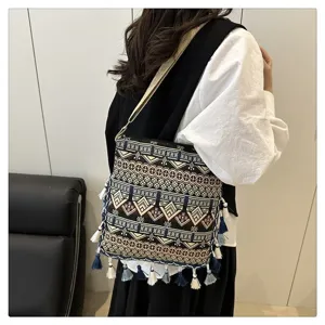 Sac à bandoulière en toile style ethnique bohème avec motifs géométriques et glands.
