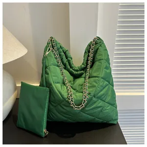 Detailaufnahme der grünen gesteppten Tasche mit goldener Kette und passendem kleinen Täschchen.