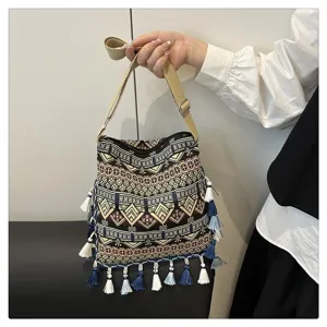 Sac à bandoulière style ethnique avec motifs géométriques tissés et franges décoratives.