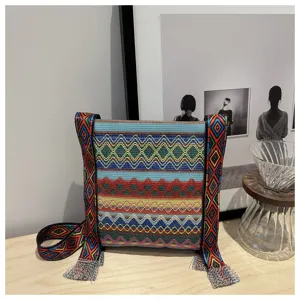 Détail de sac bandoulière tissé de style ethnique, motif géométrique coloré avec large sangle.