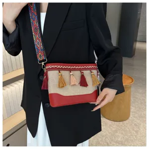 Vue détaillée d'un sac bandoulière en toile ethnique tendance avec sangle et de beaux glands.