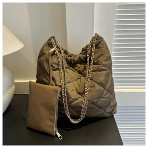Detailaufnahme der eleganten gesteppten Handtasche mit Metallkette und passender Tasche.