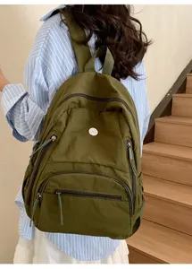 Détail du sac à dos décontracté en toile verte avec poches multiples et lanières.