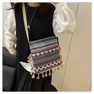 Sac bandoulière en toile style ethnique avec motif géométrique et glands chics.
