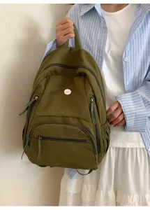 Sac à dos décontracté en nylon vert olive, vue détaillée avec poche zippée et badge.