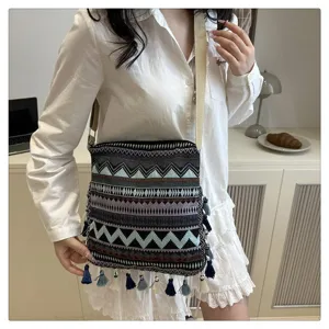 Vue détaillée d'un sac porté épaule ethnique tissé avec franges et motif géométrique boho.