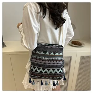 Sac à bandoulière en toile ethnique bohème avec des pompons, sac fourre-tout tendance.