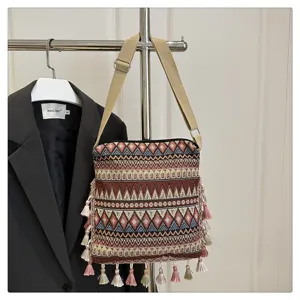 Sac bandoulière tissé ethnique avec des glands élégants et des motifs géométriques chics.