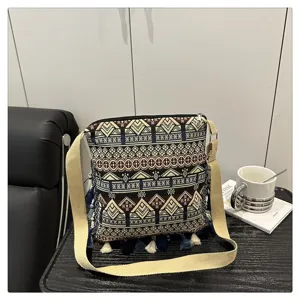 Sac bandoulière en toile style ethnique avec motifs géométriques et franges délicates.