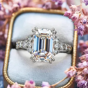 Primer plano detallado de un elegante anillo con piedra de talla esmeralda en terciopelo