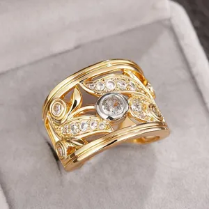 Close-up detail of the wide hollow leaf patterned two-tone zirconia ring in display.