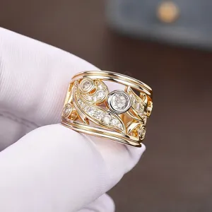 Detailed close-up of a wide two-tone plated hollow leaf pattern ring set with sparkly zircons.