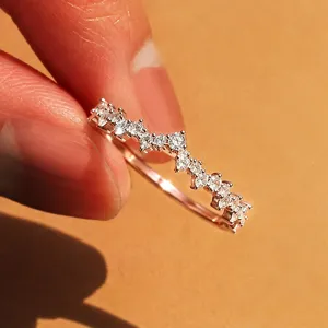 Anillo fino minimalista de circonita en onda, foto detallada en primer plano mujer.
