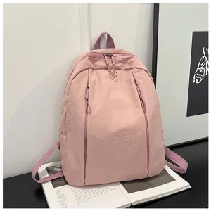 Vue de détail du sac à dos rose, design minimaliste avec poches avant zippées.