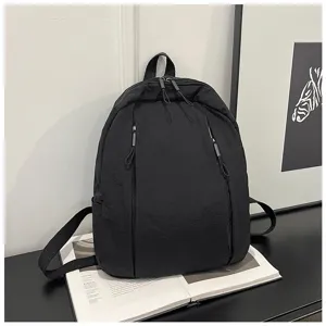 Sac à dos noir uni décontracté en détail, léger et idéal pour les trajets quotidiens.