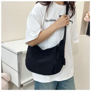 Sac bandoulière noir en nylon pour femme, sac dumpling minimaliste et élégant pour usage quotidien.