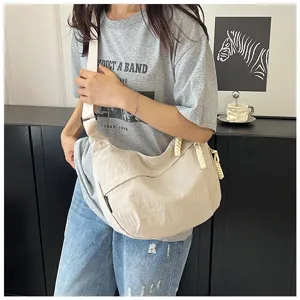Vue détaillée du sac porté épaule en nylon décontracté, style hobo minimaliste quotidien.