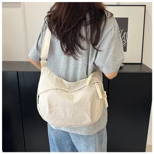 Vue détaillée du sac à bandoulière décontracté en nylon porté par le modèle, style simple.