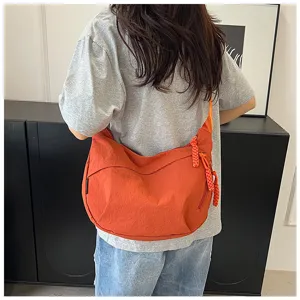 Détail de sac bandoulière décontracté en nylon, design de sac fourre-tout orange simple.