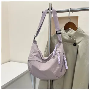 Vue détaillée du sac porté épaule en nylon décontracté mauve clair avec tirettes tressées.