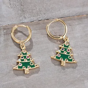 Primer plano detallado de pendientes de árbol de navidad dorados con piedras de circonita.