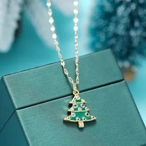 Detalle en primer plano del collar con colgante de árbol de navidad dorado con circonitas.
