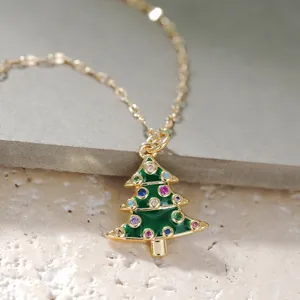 Primer plano detalle de un collar con colgante de árbol de navidad dorado con piedras de colores.