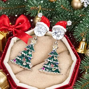 Vista detallada de pendientes de árbol de navidad con circonitas de colores y gorro de Papá Noel.