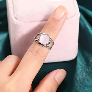 Primer plano detallado del anillo vintage plateado con piedra de resina rosa.